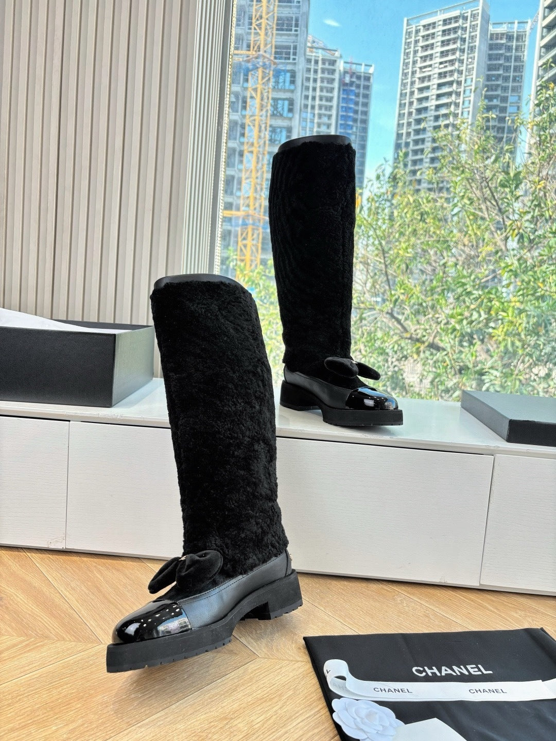 KNEE-HIGH SHEARLING BOOTS WITH PATENT CAP TOE AND BOW DETAIL