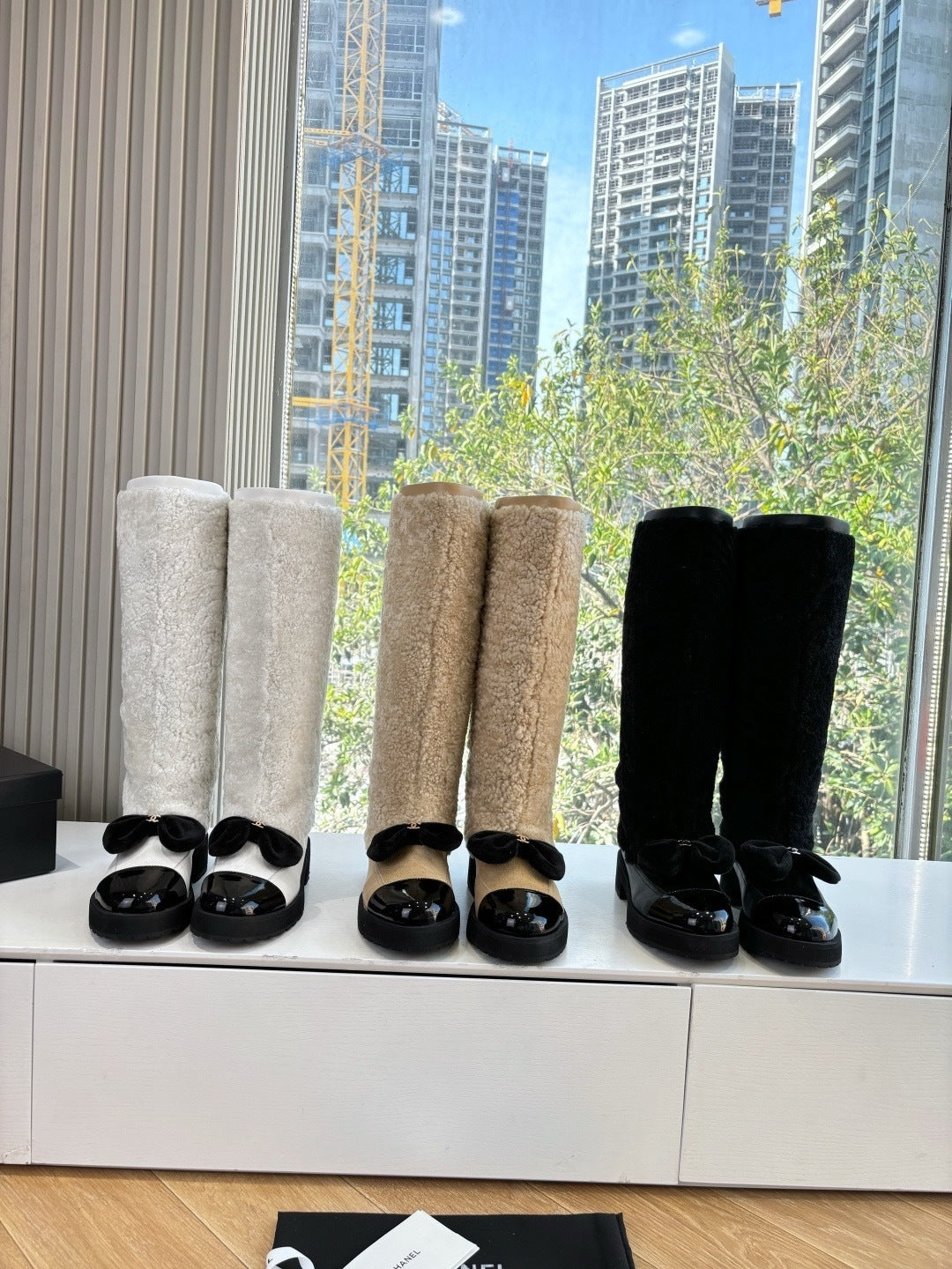 KNEE-HIGH SHEARLING BOOTS WITH PATENT CAP TOE AND BOW DETAIL