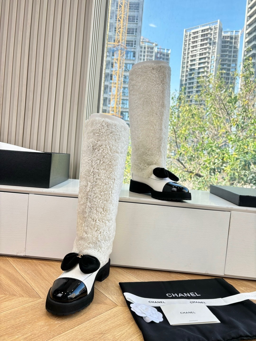 KNEE-HIGH SHEARLING BOOTS WITH PATENT CAP TOE AND BOW DETAIL