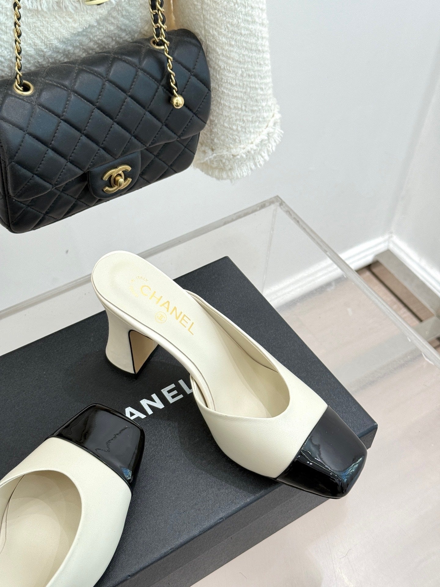 Elfenbeinfarbene und schwarze zweifarbige Pantoletten mit Kappe