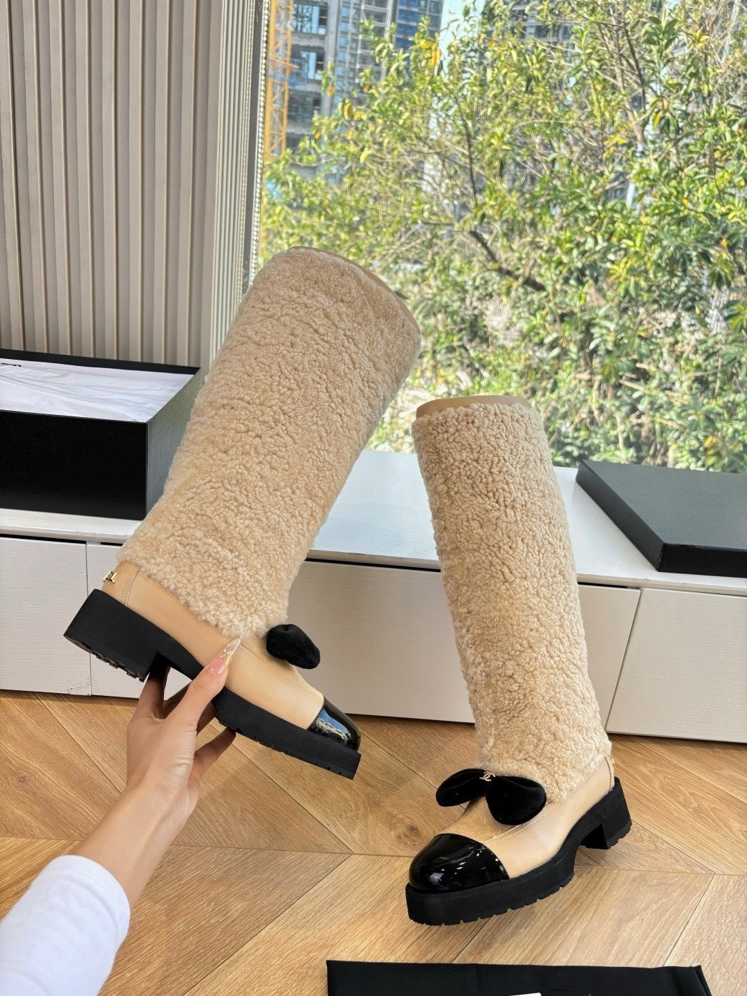 KNEE-HIGH SHEARLING BOOTS WITH PATENT CAP TOE AND BOW DETAIL