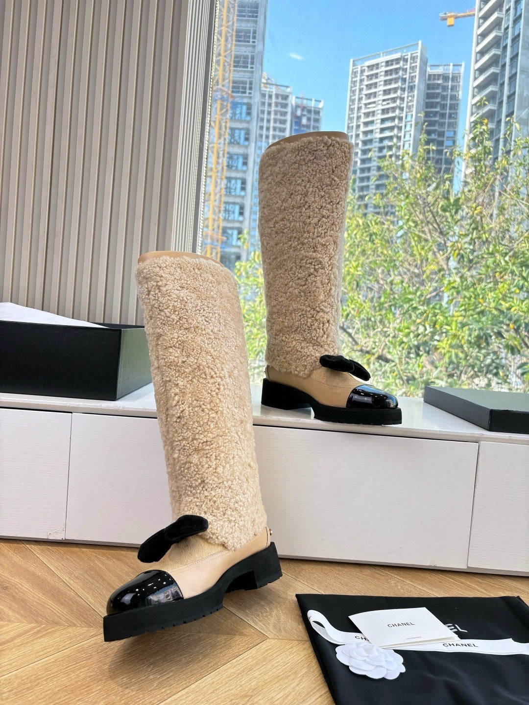 KNEE-HIGH SHEARLING BOOTS WITH PATENT CAP TOE AND BOW DETAIL