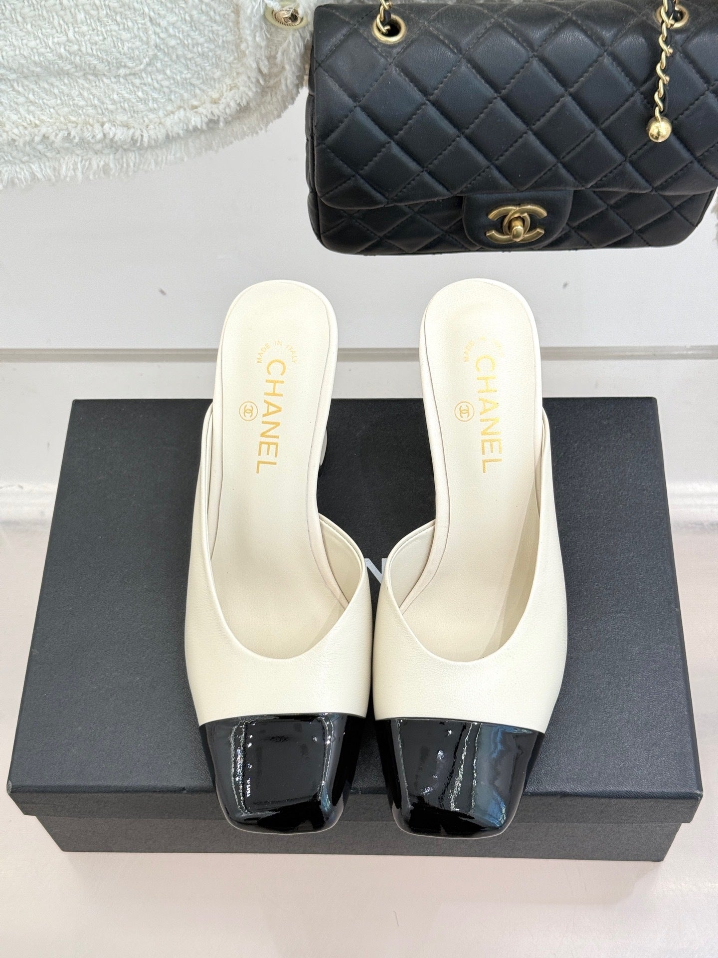 Elfenbeinfarbene und schwarze zweifarbige Pantoletten mit Kappe