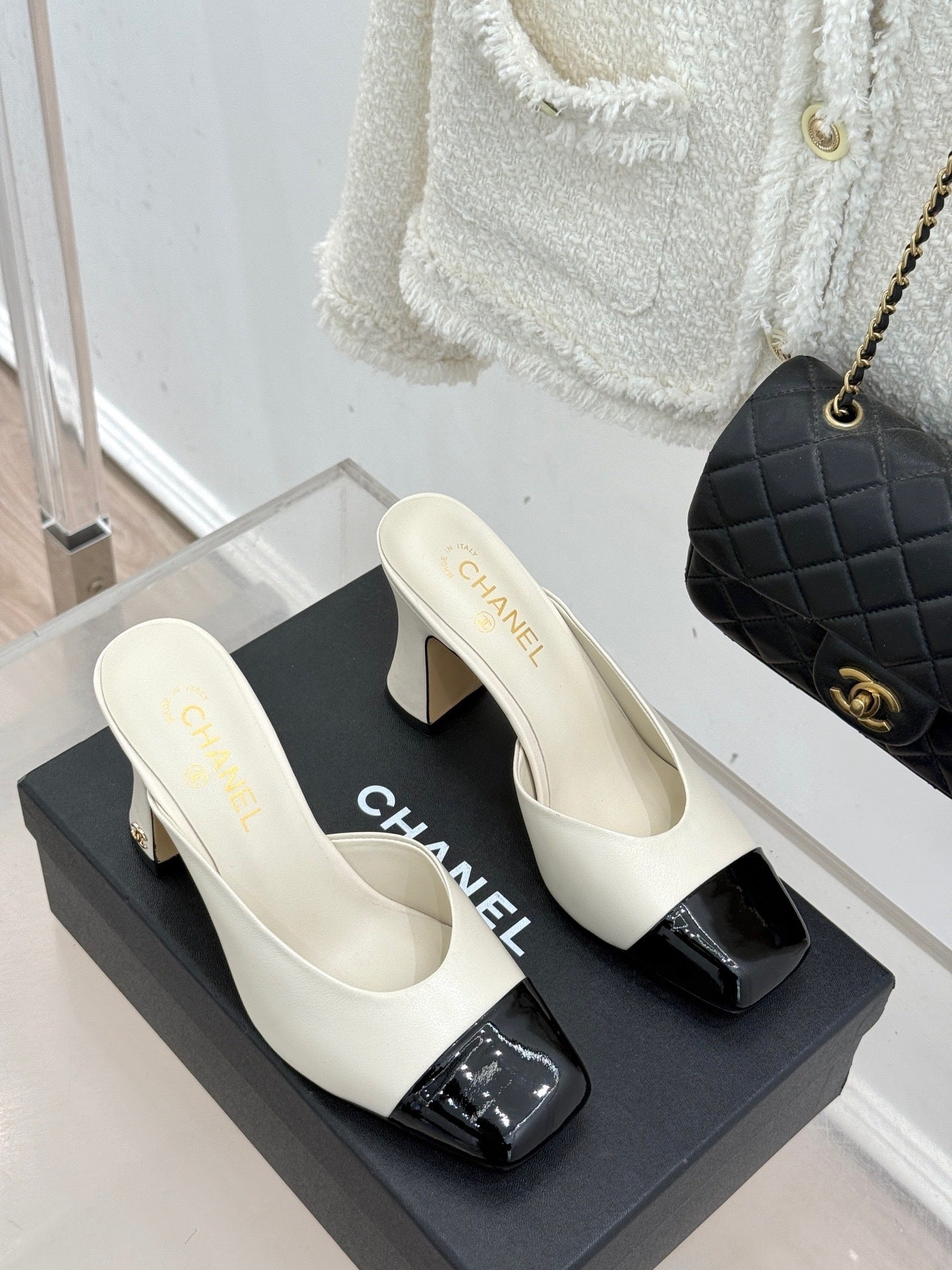 Elfenbeinfarbene und schwarze zweifarbige Pantoletten mit Kappe