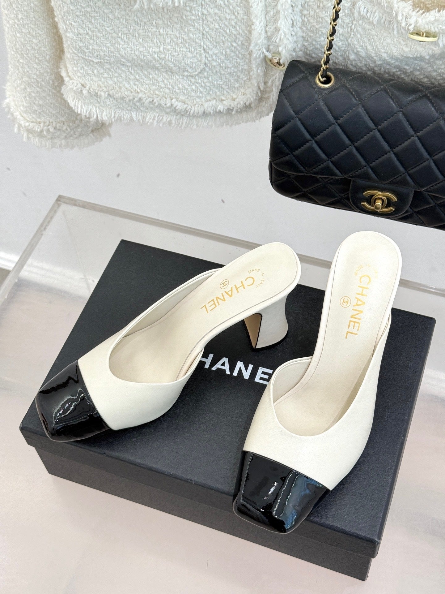 Elfenbeinfarbene und schwarze zweifarbige Pantoletten mit Kappe